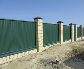 Зеленый забор с кирпичными столбами